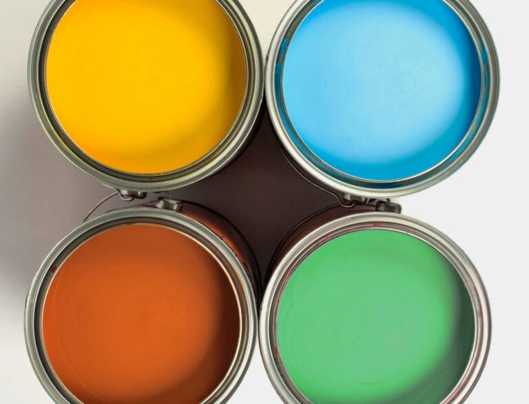 Cuatro latas de pintura de colores cálidos y fríos